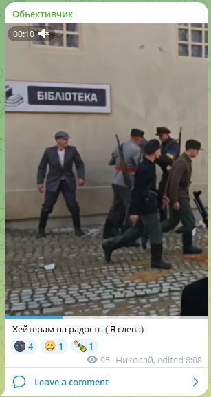 📋 Telegram «Объективчик» (00:10): мужчина в сером пиджаке и кепке (слева) стоит перед зданием с вывеской «БІБЛІОТЕКА»; мимо идут люди в военной форме с оружием; подпись: «Хейтерам на радость ( Я слева»; 4 реакции; 95 просмотров; Николай, edited 8:08.