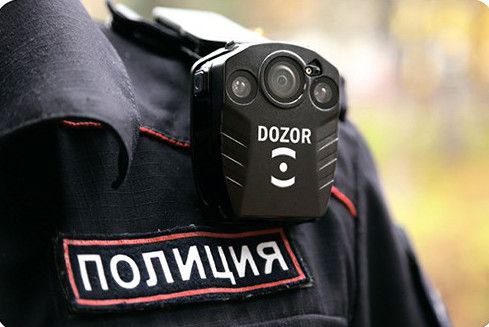 Фото крупным планом: на форме сотрудника российской полиции (нашивка «ПОЛИЦИЯ») закреплена нагрудная видеокамера DOZOR с несколькими объективами.