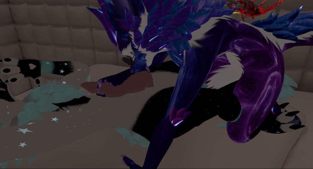 Скриншот VRChat. Два антропоморфных персонажа-дракона: тёмно-синий с синими крыльями и перьями (на заднем плане) и фиолетово-чёрный с тёмными крыльями (на переднем). Интерьер мягкой комнаты с бежевыми стенами.