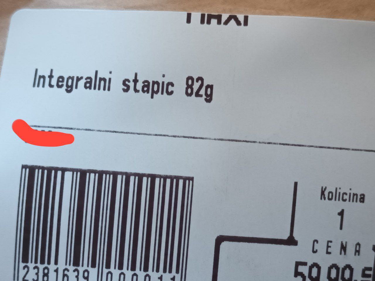 Фото этикетки товара сербского супермаркета Maxi (вверху надпись «MAXI»). Продукт: «Integralni stapic 82g» (цельнозерновые хлебные палочки). Штрихкод: 2381639 000011. Количество (Kolicina): 1. Цена (Cena): 59,99 (динаров). Нарисованная красная стрелка указывает влево, в сторону штрихкода.