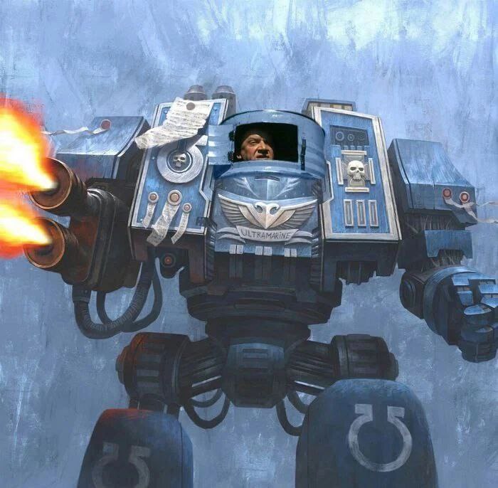 Арт-фотожаба: боевой дредноут Ультрамаринов (Warhammer 40K) в сине-стальных доспехах с символикой «ULTRAMARINE» на груди и эмблемой ордена. В открытом иллюминаторе кабины — фотография реального мужчины. Дредноут ведёт огонь из орудия (огненная струя слева). Синеватый фон.