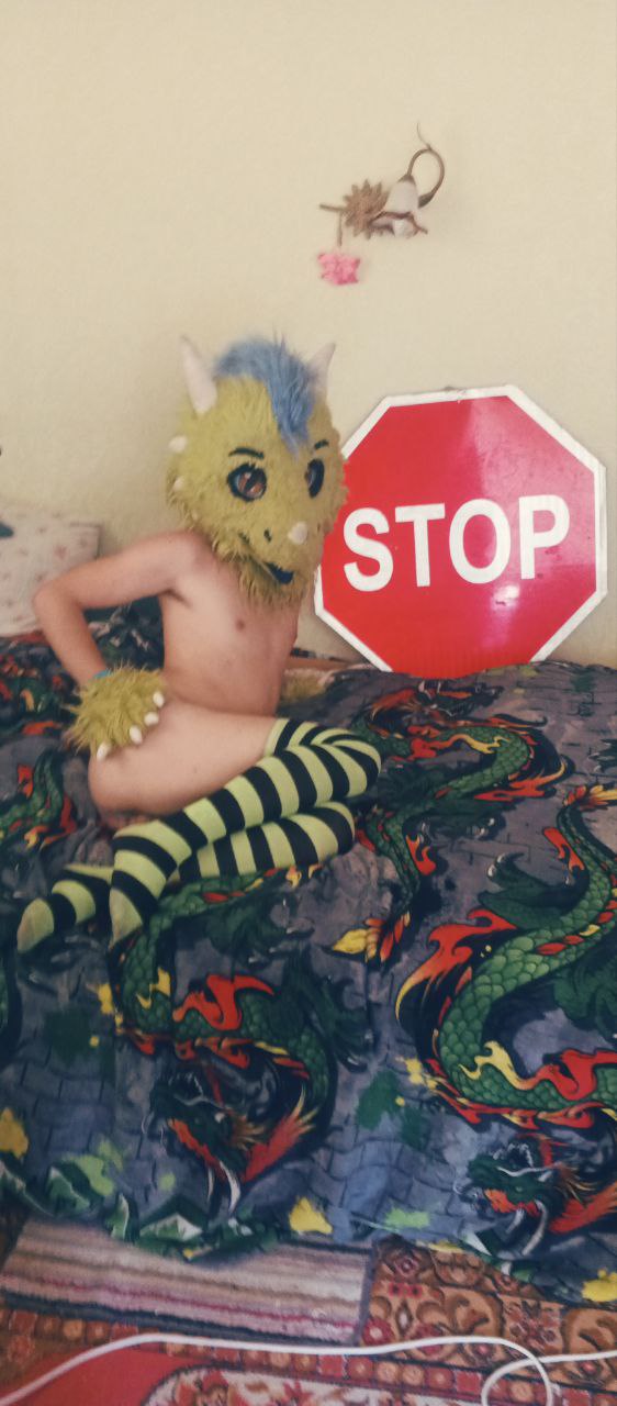 Фото подписчика в жёлто-голубом фурсьюте рядом со знаком STOP на кровати (3/4).
