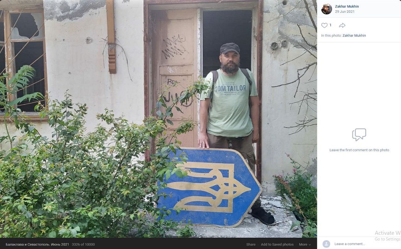 Мужчина держит украинский щит с трезубцем у разрушенного здания (4/6).