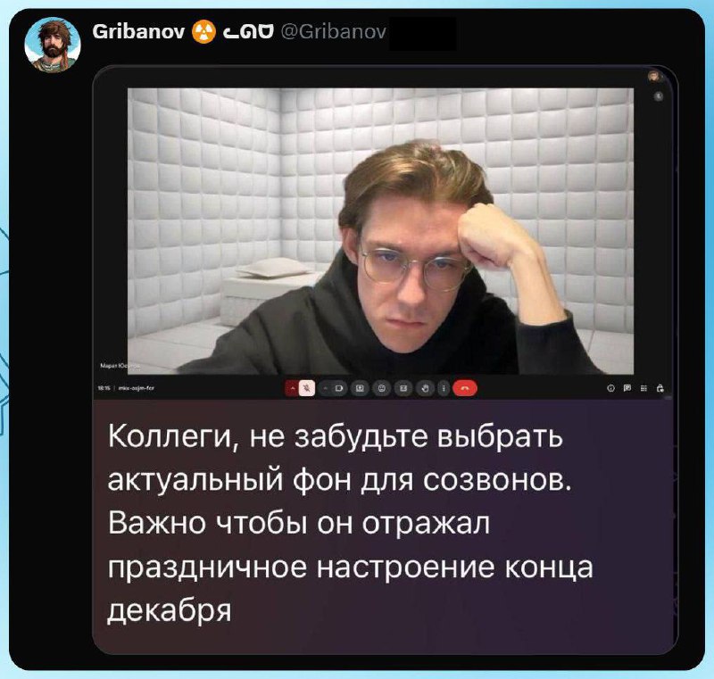 Твит @Gribanov: скриншот онлайн-звонка — молодой мужчина в чёрной толстовке и очках сидит на фоне белой комнаты с мягкими стенами (напоминает психиатрическую палату); подпись «Коллеги, не забудьте выбрать актуальный фон для созвонов. Важно чтобы он отражал праздничное настроение конца декабря».