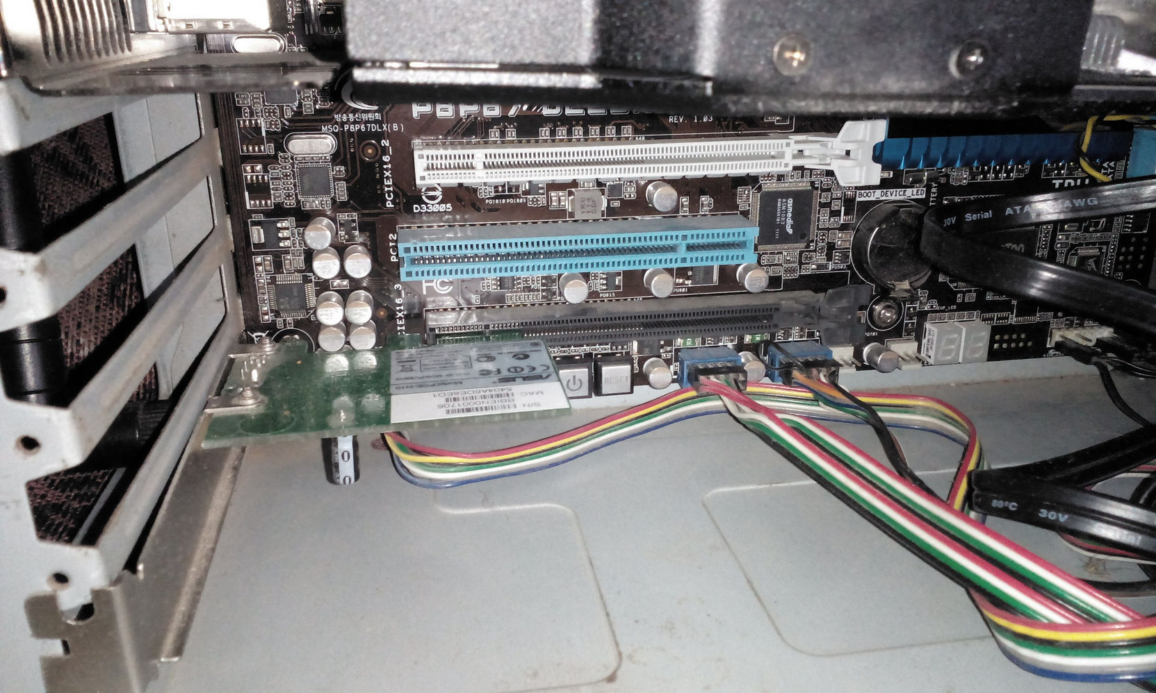 Материнская плата MSI P45 в корпусе: два синих слота PCIe x16, установлена плата расширения; разноцветные провода передней панели