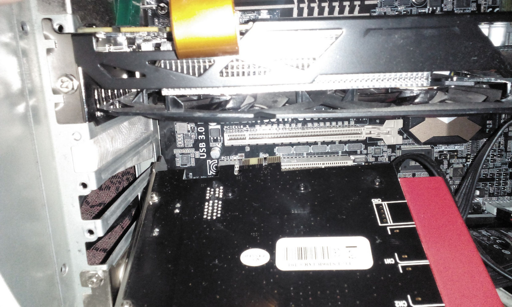 PCIe-карта USB 3.0 в слоте материнской платы, рядом красный компонент; крупный план слотов PCIe x1 и x16