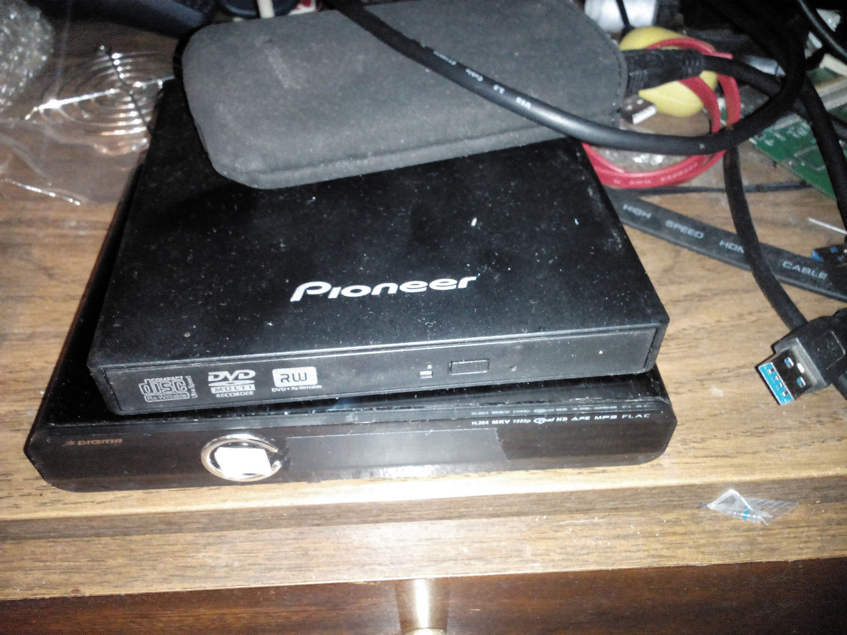 На столе: внешний DVD-привод Pioneer DVD+RW и медиаплеер Digma; рядом USB 3.0-кабель и прочее железо