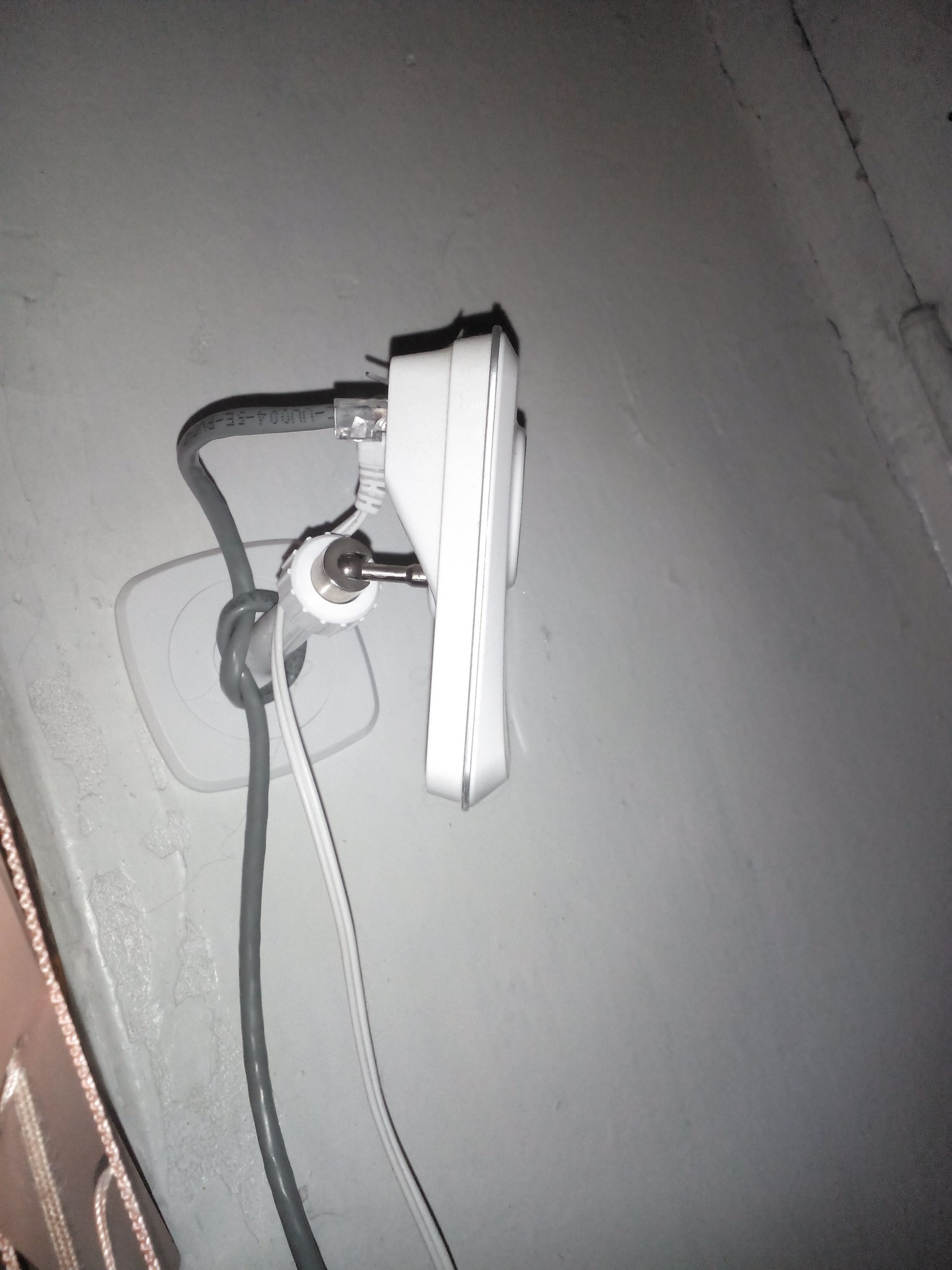 Настенная розетка RJ45 с подключёнными кабелями: ethernet и телевизионный коаксиальный; установлена в стене