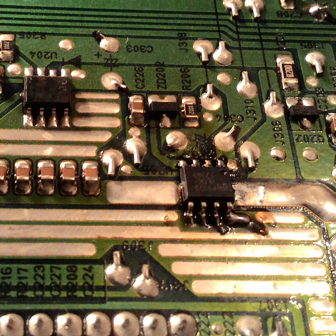 Макрофото зелёной печатной платы: SMD-компоненты — конденсаторы (C303, C302 и др.), резисторы, микросхемы в корпусах SOIC, паяные контакты; маркировка дорожек и компонентов (U204, D202 и др.)