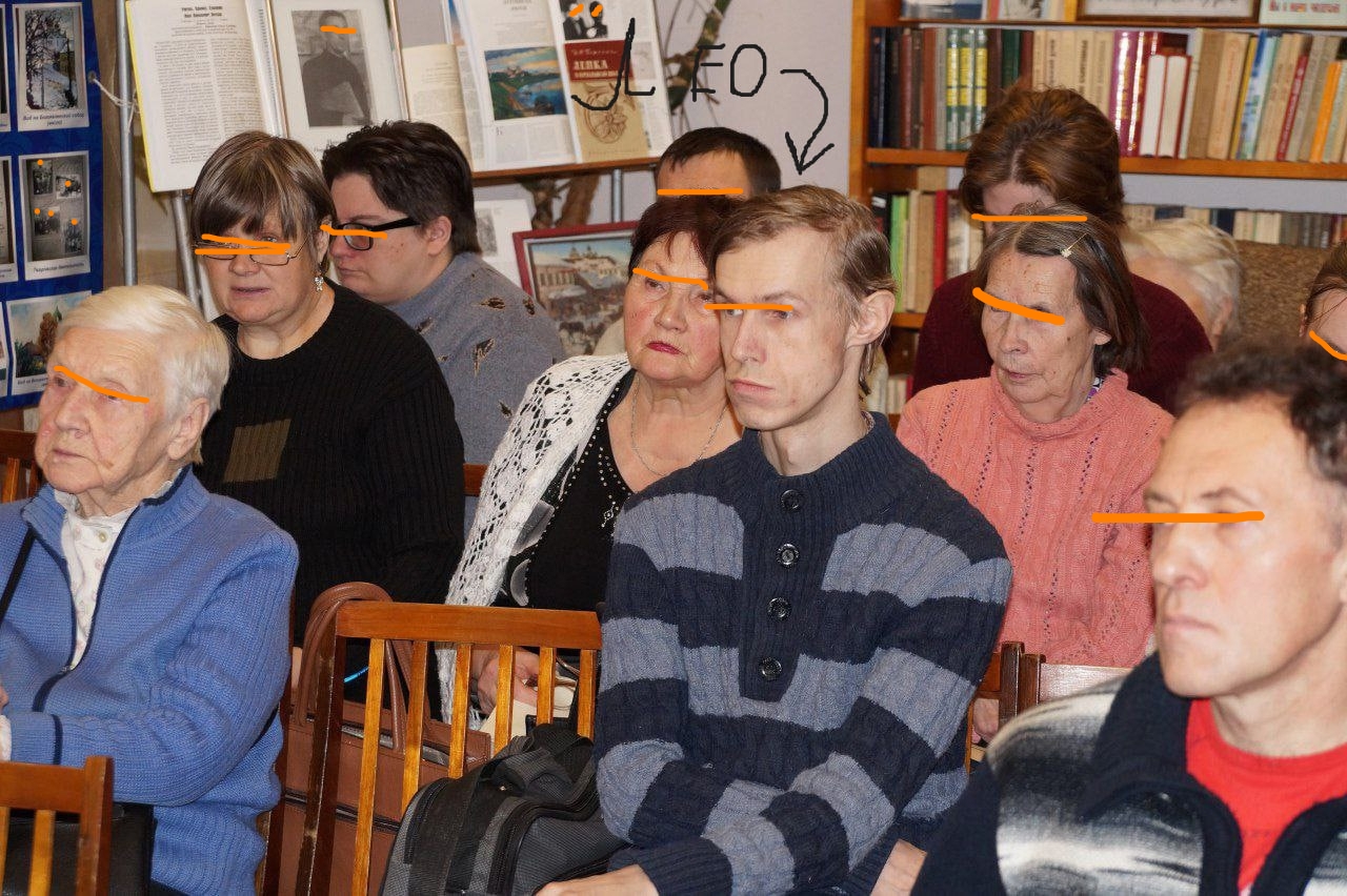 📷 Группа людей сидит в зале; оранжевые горизонтальные полосы поверх глаз; стрелка с надписью «ЛЕО» указывает на одного из них.