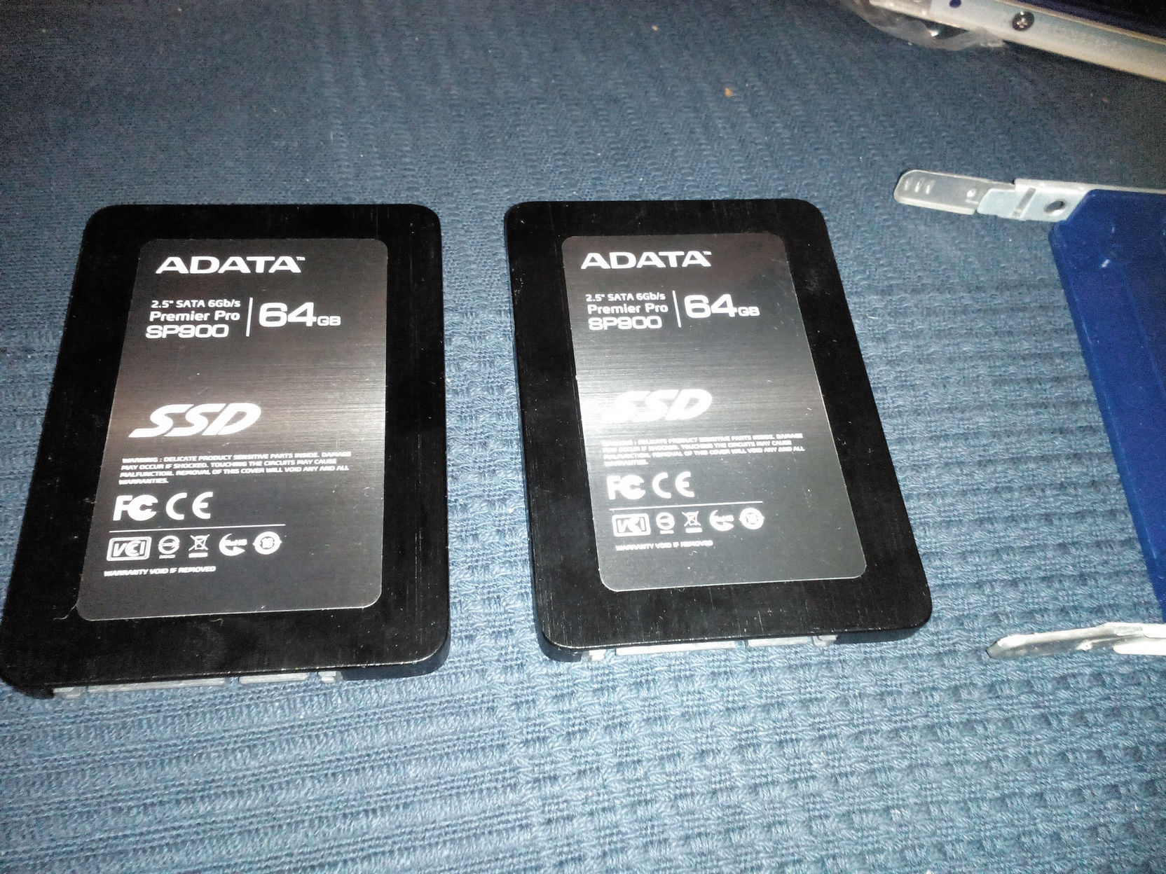 Два SSD диска ADATA Premier Pro SP800 64GB SATA 6Gb/s лежат рядом на синей поверхности