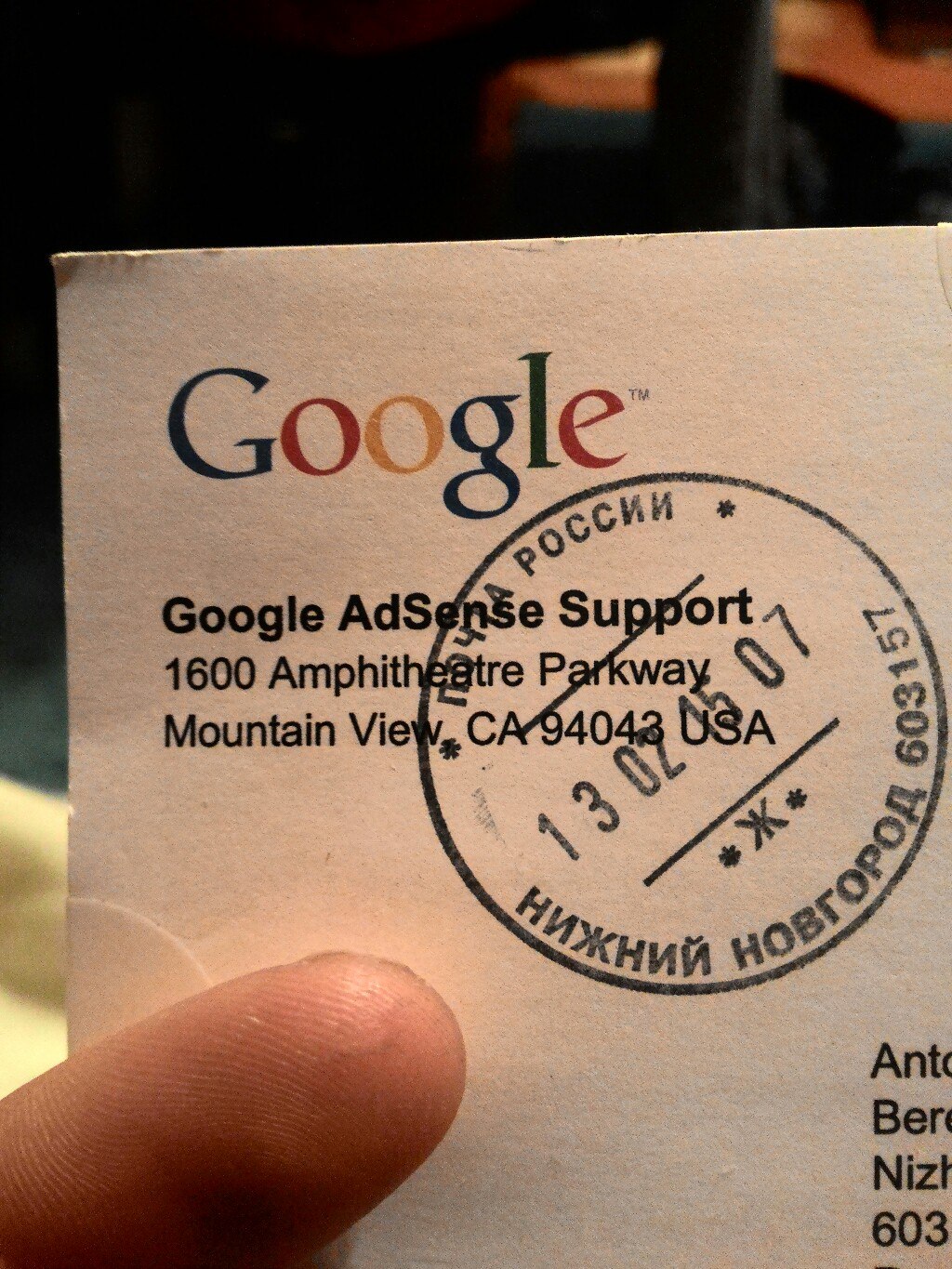 Конверт от Google AdSense Support, адрес: 1600 Amphitheatre Parkway, Mountain View, CA 94043 USA; на конверте синий круглый почтовый штамп «Почта России — Нижний Новгород 603157» с датой 13.02; логотип Google в цвете