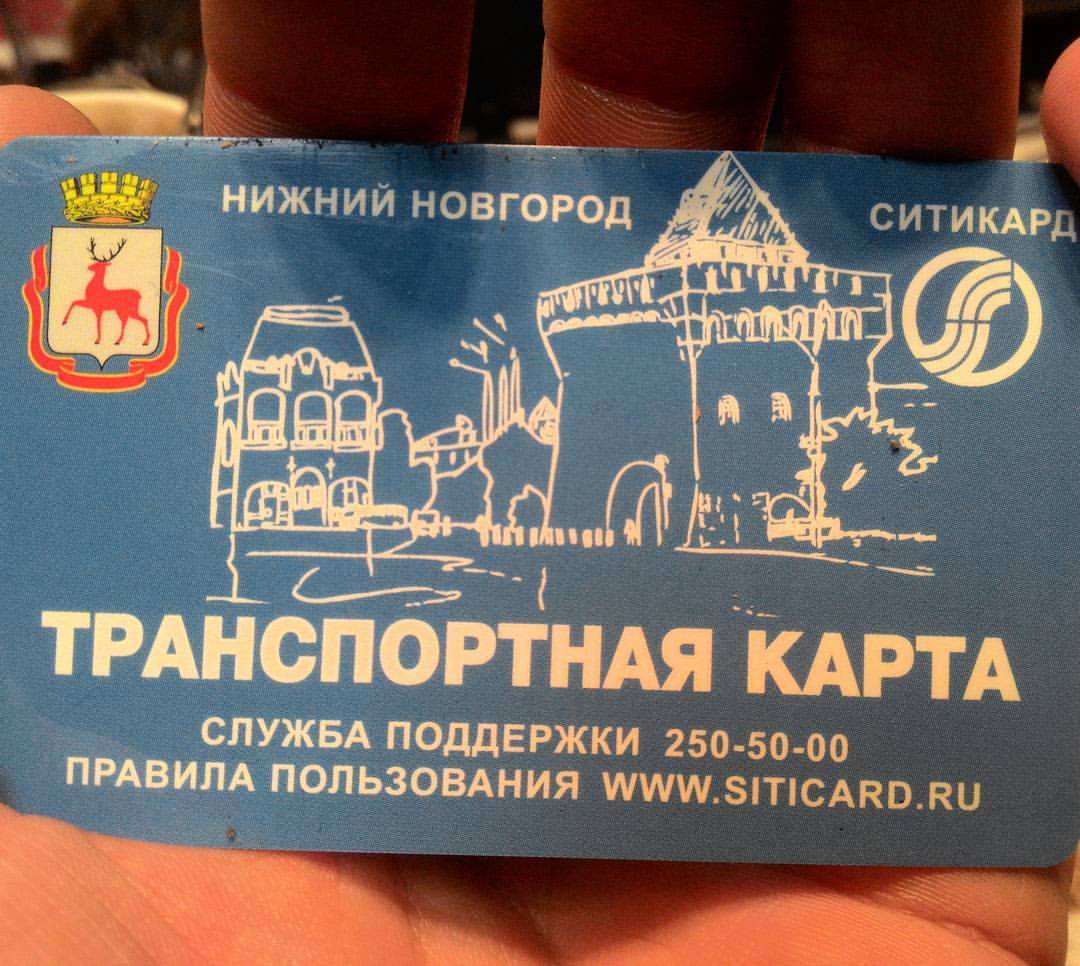 Фото синей транспортной карты «Ситикард» Нижнего Новгорода (держат пальцы): вверху слева герб города (олень), справа логотип «СИТИКАРД»; по центру рисунок нижегородского Кремля; крупно «ТРАНСПОРТНАЯ КАРТА»; мелко «СЛУЖБА ПОДДЕРЖКИ 250-50-00» и «ПРАВИЛА ПОЛЬЗОВАНИЯ WWW.SITICARD.RU»