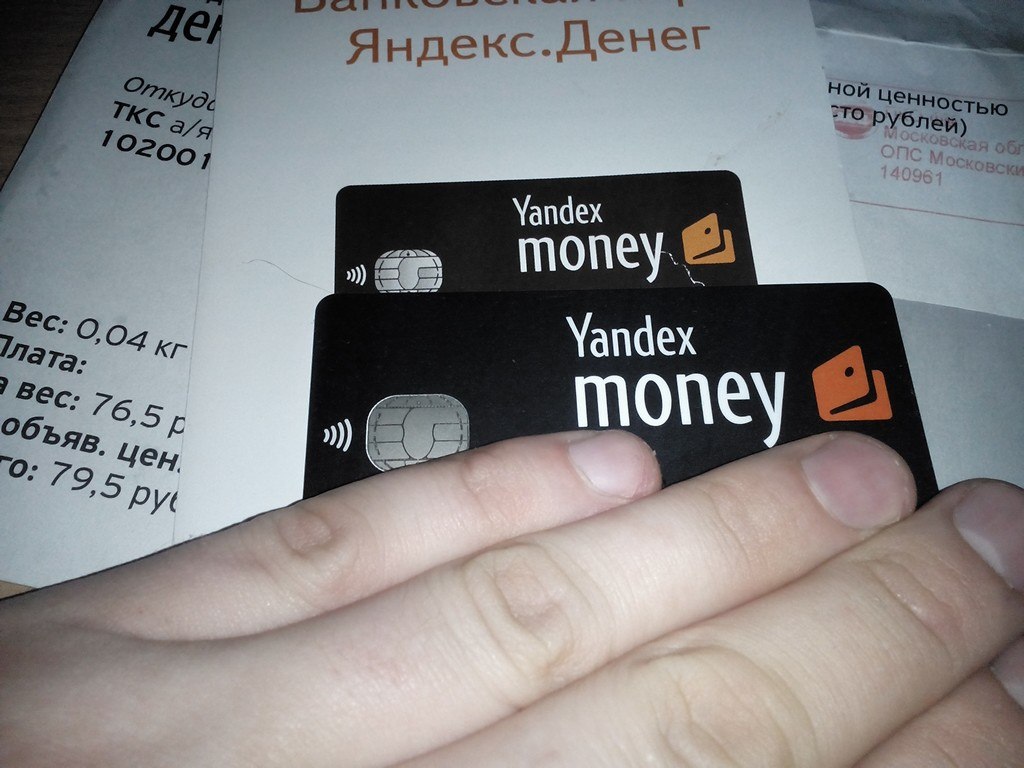 В руке две чёрные карты «Yandex money» с NFC-чипом и чипом EMV; на фоне почтового конверта с квитанцией (79.5 руб., ТКС а/я)