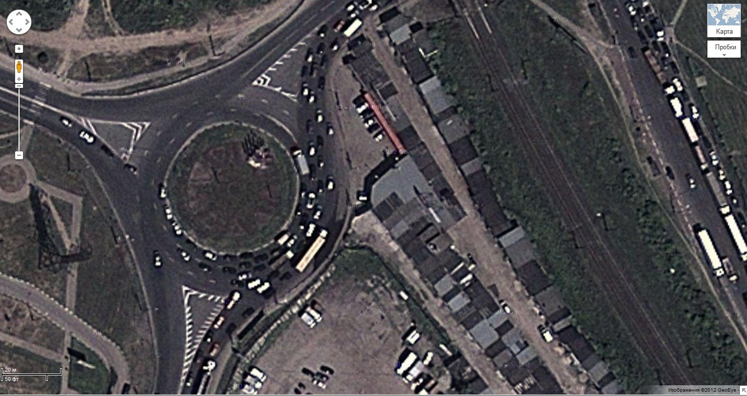 Скриншот Google Maps со спутниковым видом кольцевой развязки с плотным трафиком, режим Пробки