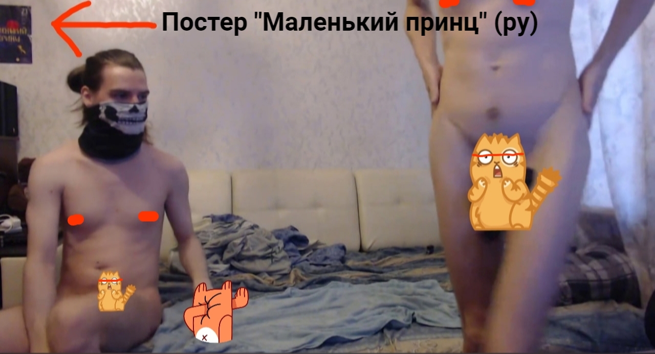 📷 Стоп-кадр видео: двое мужчин стоят без одежды (интимные части тела прикрыты наклейками-стикерами с мультяшными котами); левый — в маске «черепа»; надпись со стрелкой влево «Постер «Маленький принц» (ру)»; на заднем плане диван и стена.