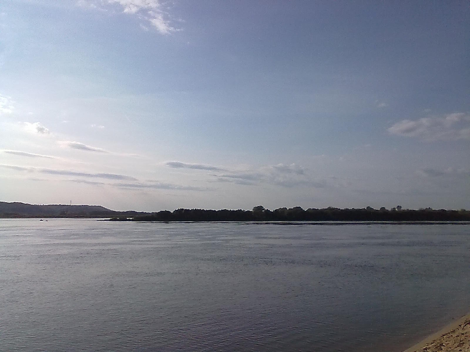Широкий вид на реку Ока с песчаного берега, спокойная вода, деревья вдали