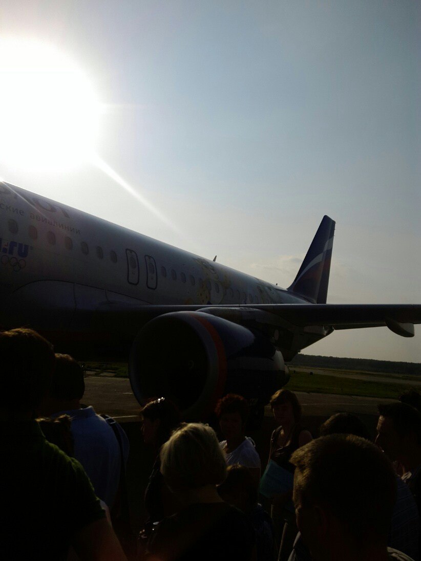 Очередь пассажиров на перроне поднимается в самолёт Аэрофлота с олимпийской ливреей, яркое солнце, синее небо
