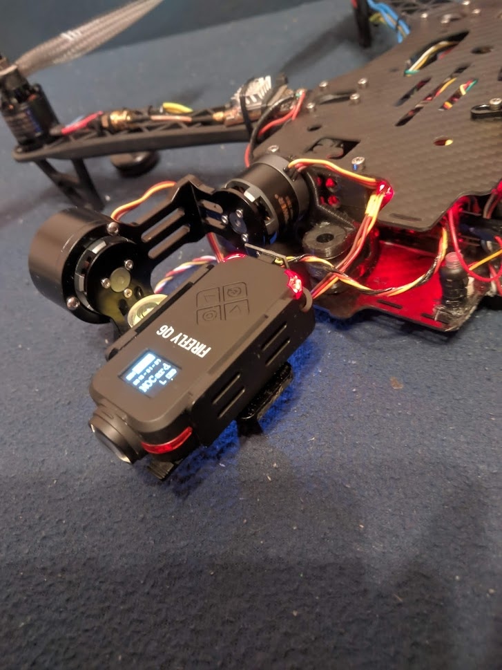 📷 Два чёрных бесколлекторных мотора FPV-дрона с красными монтажными кронштейнами; провода жёлтый, красный, синий, чёрный с паяными соединениями.