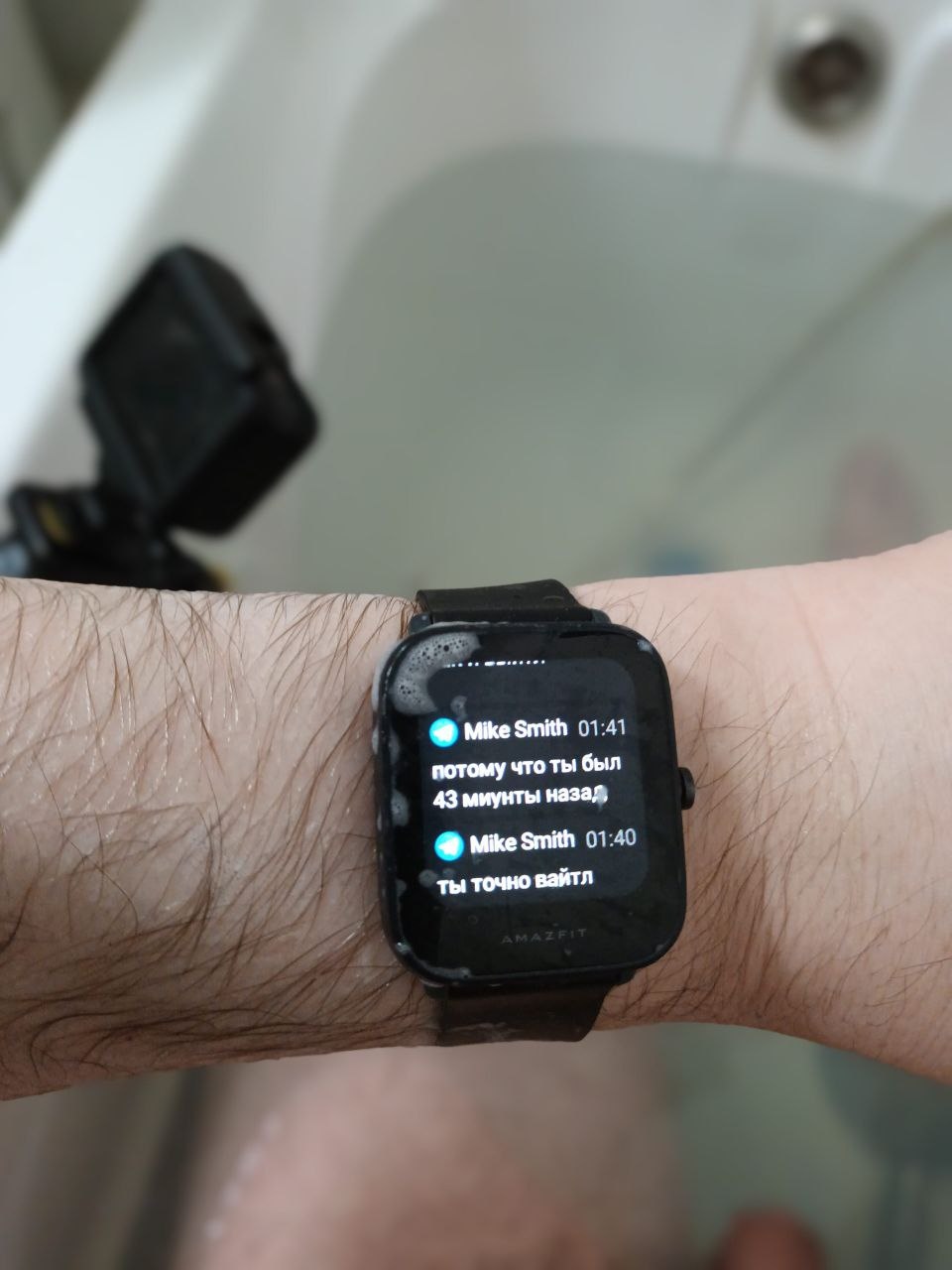 📷 Смарт-часы Amazfit на руке (мокрые, фон — ванна): уведомления от Mike Smith — «01:41 потому что ты был 43 минуты назад)» и «01:40 ты точно вайтл»