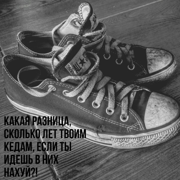 Чёрно-белое фото: пара поношенных низких кед Converse Chuck Taylor All Star (логотип звезды на щиколотке, белые шнурки) на деревянном полу; внизу подпись «КАКАЯ РАЗНИЦА, СКОЛЬКО ЛЕТ ТВОИМ КЕДАМ, ЕСЛИ ТЫ ИДЕШЬ В НИХ НАХУЙ?!»