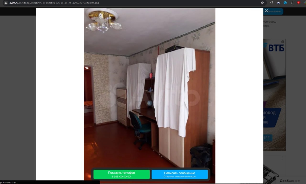 📋 Скриншот Авито (avito.ru/melitopol/kvartiry/...): объявление о продаже 3-комнатной квартиры 62,5 м² в Мелитополе; интерьер — светлые обои, шкаф-купе накрытый белой тканью, рабочий стол, красный линолеум; баннер ВТБ; кнопки «Показать телефон» и «Написать сообщение».