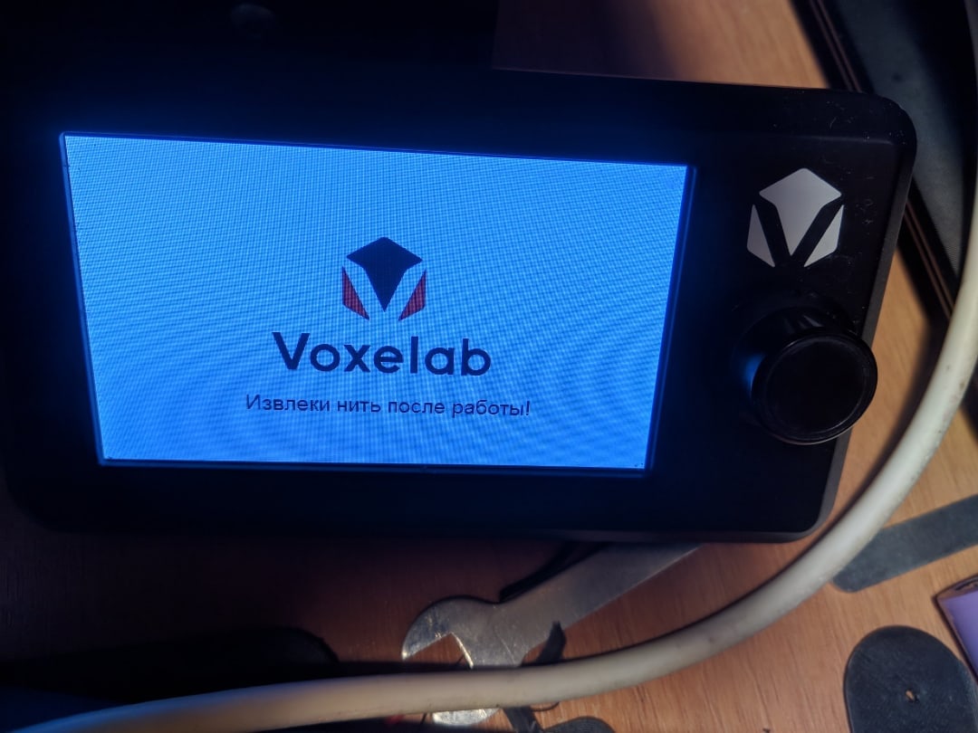 📷 VR-шлем Voxelab в руках: чёрный с синими акцентами, экран с логотипом «Voxelab» и русским текстом; деревянная поверхность.