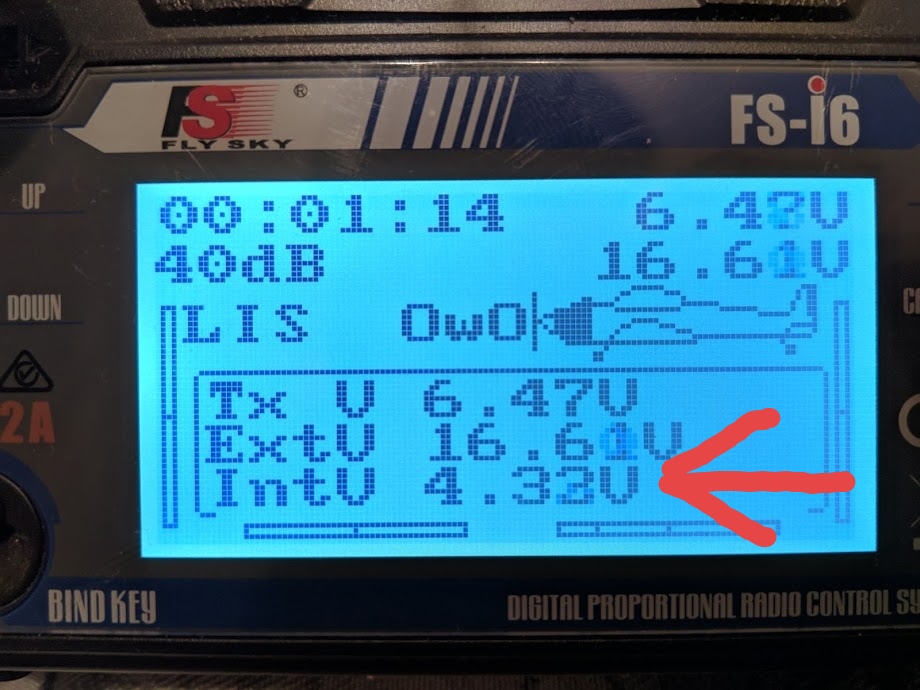 Скриншот дисплея FlySky FS-i6: «00:01:14  6.48V / 40dB  16.61V / LIS  OwO / Tx V  6.47V / ExtV  16.61V / IntV  4.32V» (стрелка указывает на IntV 4.32V); надпись «BIND KEY  DIGITAL PROPORTIONAL RADIO CONTROL S[YSTEM]»