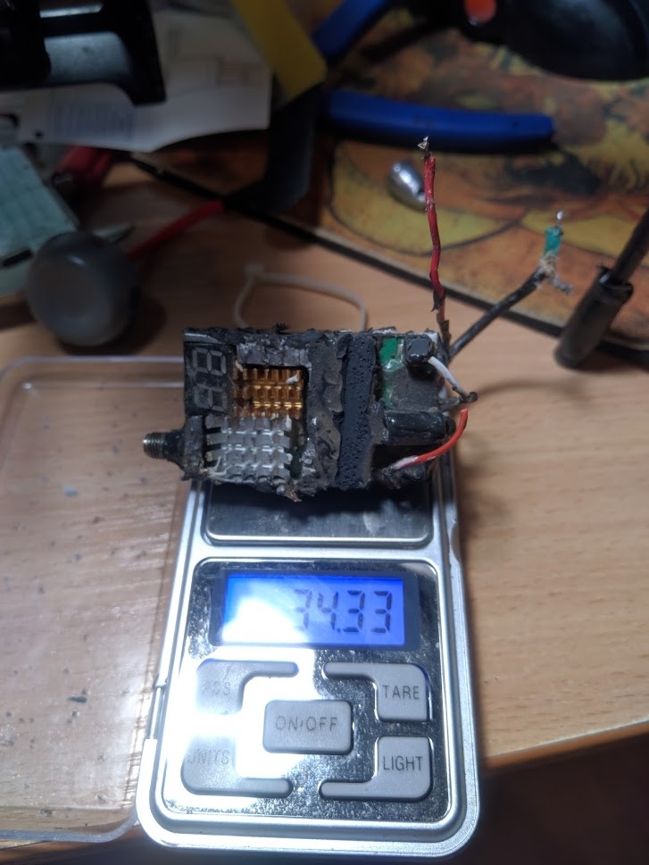 📷 Сгоревший/оплавленный электронный модуль (FPV-видеопередатчик) на ювелирных весах: дисплей «34,33» г, красные и белые провода, обгоревший корпус