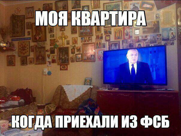 Мем: фото жилой комнаты — стены полностью увешаны православными иконами, у стены стоит большой плоский телевизор, на экране мужчина в костюме (новостная передача); поверх фото надписи белым крупным шрифтом: вверху «МОЯ КВАРТИРА», внизу «КОГДА ПРИЕХАЛИ ИЗ ФСБ»