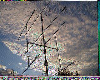 SSTV-изображение: антенная система (Яги) крупным планом на фоне облачного неба; умеренный шум