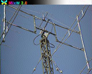SSTV-изображение, декодированное в MixW 2.0: Яги-антенна на металлической мачте-башне, вид снизу вверх на фоне голубого неба; относительно чёткое изображение