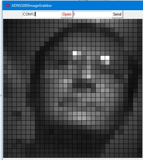 Скриншот «ADNS3080ImageGrabber»: поле «COM12», кнопки «Open» и «Send»; в области просмотра — пиксельное низкокачественное изображение лица автора (двойной подбородок виден) через оптический сенсор мыши